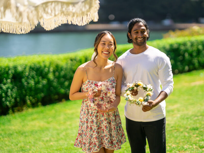 couple posing with flower wreaths